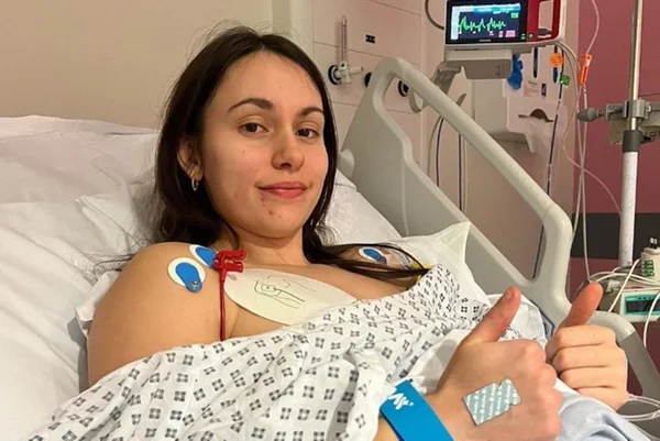 Foto mostra Faith Harrison, que é uma mulher branca de cabelos castanhos, em uma maca de hospital - Metrópoles