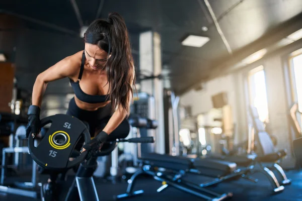 Foto colorida de mulher praticando musculação na academia - Morte na Smart Fit reforça cuidados com o coração antes do treino - Metrópoles