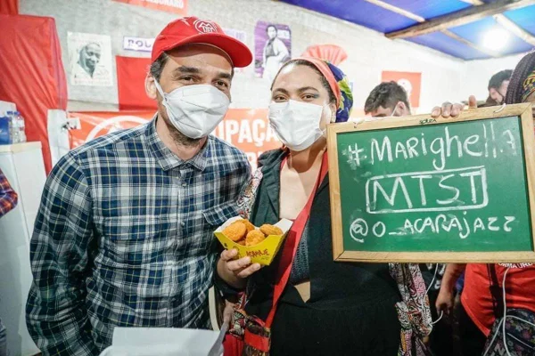 wagner moura e bia souza com placa escrito mariguella mtst @o_acarajazz