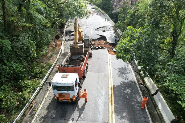 Imagem colorida mostra caminhão concertando a destruição em São Sebastião no litoral de São Paulo - Metrópoles