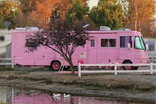na foto, motorhome cor-de-rosa estacionado