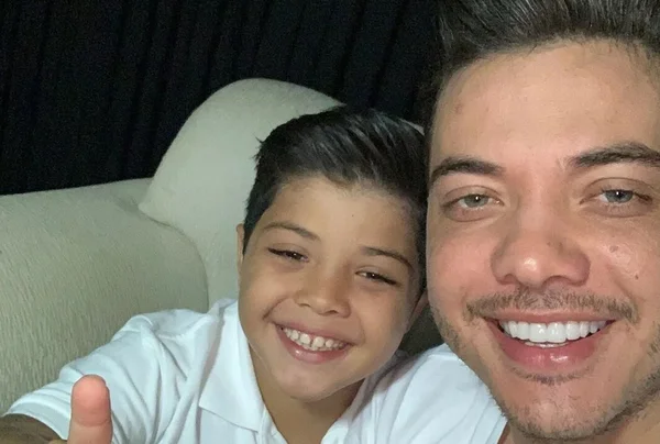 Yhudy, filho de Wesley Safadão, com 8 anos, ao lado do pai, ambos vestidos de branco - Metrópoles