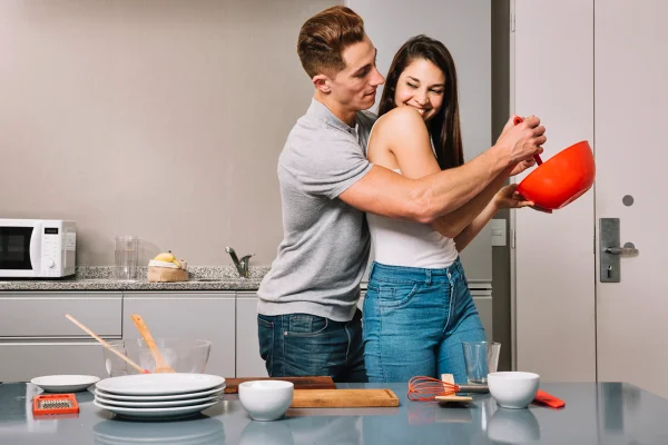 Foto colorida de casal cozinhando