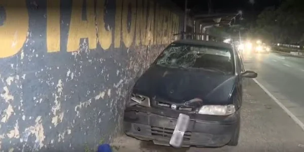 Imagem de carro com frente destruída em calçada de avenida - Metrópoles