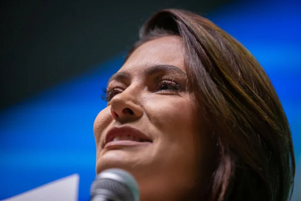 Michelle Bolsonaro com microfone durante palestra na sede de seu partido político
