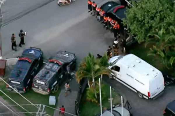 Imagem colorida de carro do IML chegando na delegacia. Metrópoles