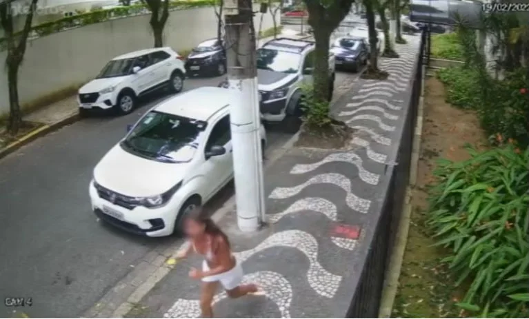 A mulher levanta do chão atordoada e corre atrás dos criminosos A mulher levanta do chão atordoada e corre atrás dos criminosos