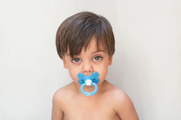menino com chupeta na boca