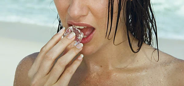 mulher colocando gelo na boca