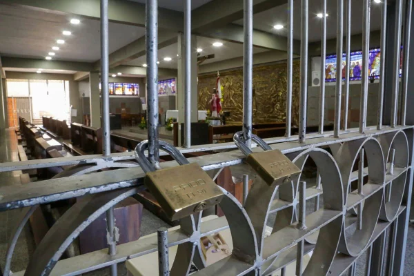 cadeados em grade de igreja. Objetos religiosos ao fundo
