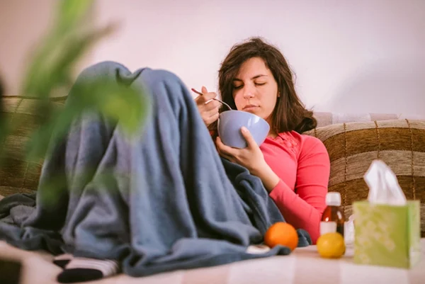 Mulher com gripe toma sopa - Metrópoles