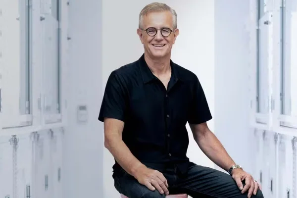 Foto de homem sentado em banco sorrindo - Metrópoles
