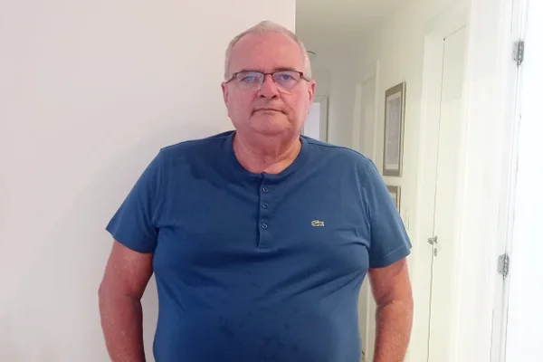 Homem em pé, com as duas mãos nos bolsos - Metrópoles