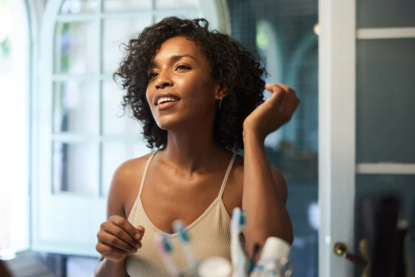 Foto colorida de uma mulher com cabelo cacheado - Metrópoles