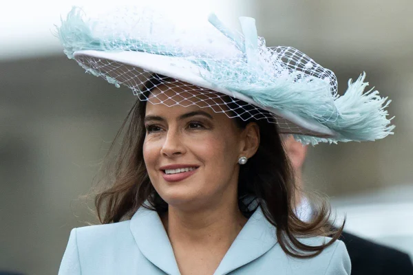 Foto colorida. Sophie Winkleman com uma roupa e chapéu azul claro
