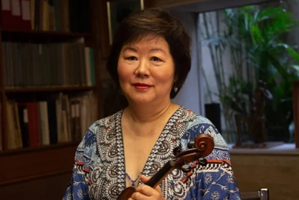 Imagem colorida de Elisa Fukuda segurando violino na mão - Metrópoles
