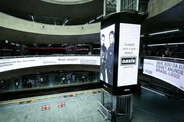 Imagem colorida de ativação da banda Oasis na Estação da Sé. Metrópoles
