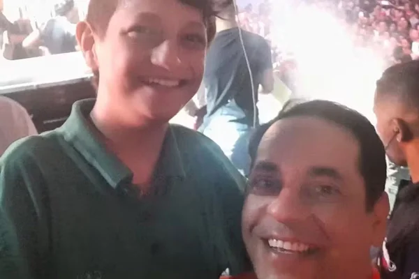 Foto colorida de Rodriguinho, cantor que morreu aos 17 anos, com seu pai, Rodrigo - Metrópoles