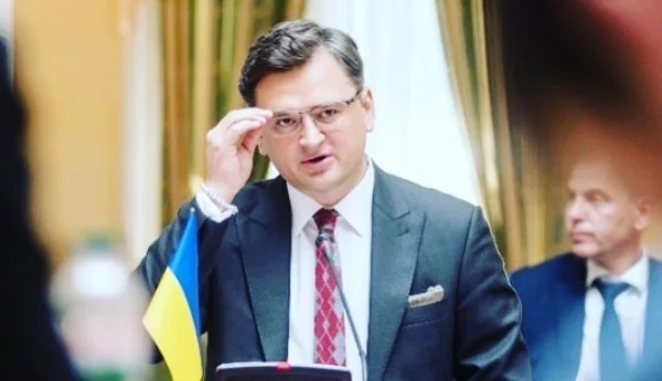 O ministro das Relações Exteriores da Ucrânia, Dmytro Kuleba, discursa na ONU. Ele fala no microfone, olhando para o público que o assiste, com a bandeira do país ao lado enquanto ajeita o óculos - Metrópoles