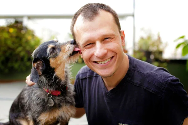 Foto colorida de um homem e um cachorro - Metrópoles