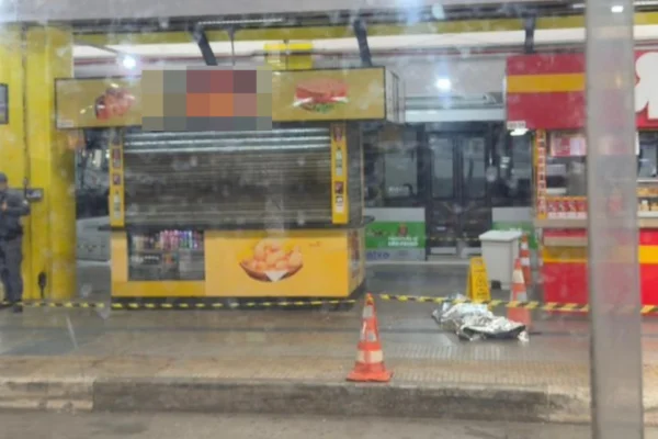 Imagem colorida de corpo sem vida em terminal de ônibus. Metrópoles
