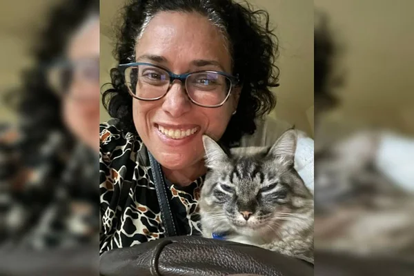 mulher cabelo preto com óculos perto de gato