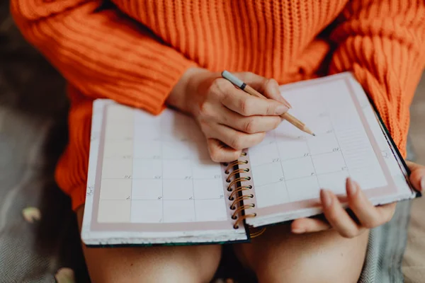Mulher organizando semana em agenda