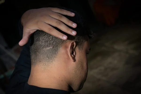 Menino de costas com a mão na cabeça