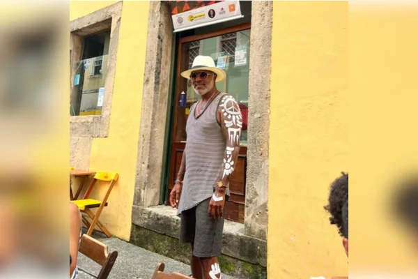 homem em frente a muro amarelo