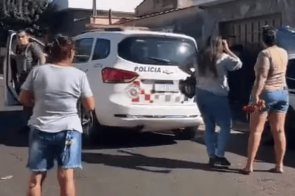 Imagem colorida de uma delegacia da Polícia Militar com algumas pessoas em pé ao redor - Metrópoles