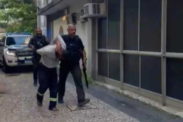 Imagem colorida de um dos suspeitos sendo preso - Metrópoles
