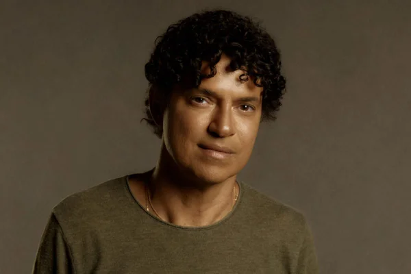 Foto colorida do cantor Jorge Vercillo. Ele usa blusa verde musgo, é negro e tem cabelo preto - Metrópoles