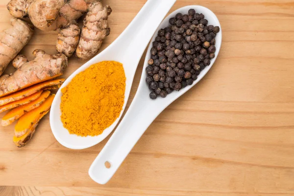 foto colorida de pimenta e cúrcuma em colheres
