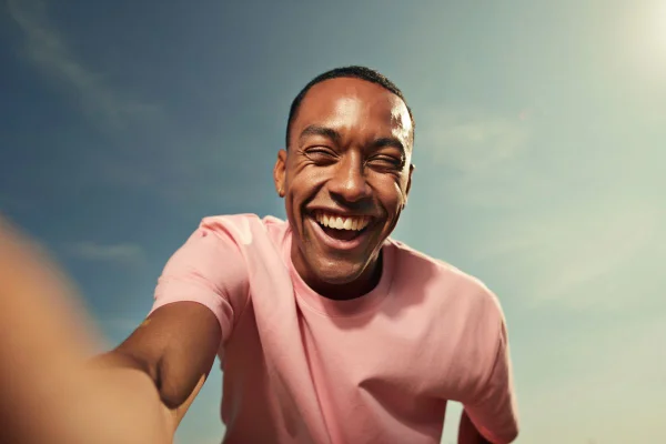 homem de camiseta rosa sorrindo