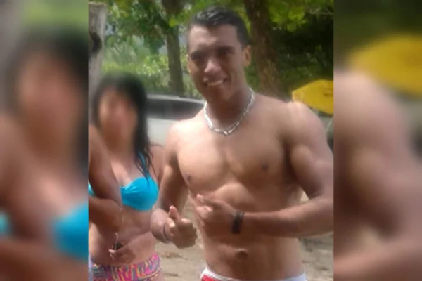 Foto colorida de Vinícius, professor de educação física, sem camiseta, ao lado de uma mulher com rosto borrado - Metrópoles