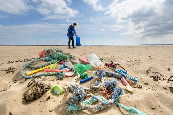 Homem em praia poluída