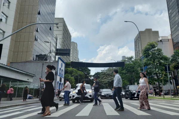 Imagem mostra pessoas em avenida - Metrópoles