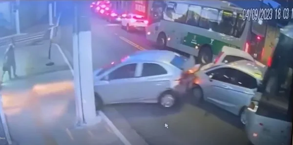 Imagem colorida de carros atravessados em avenida, empurados por ônibus - Metrópoles