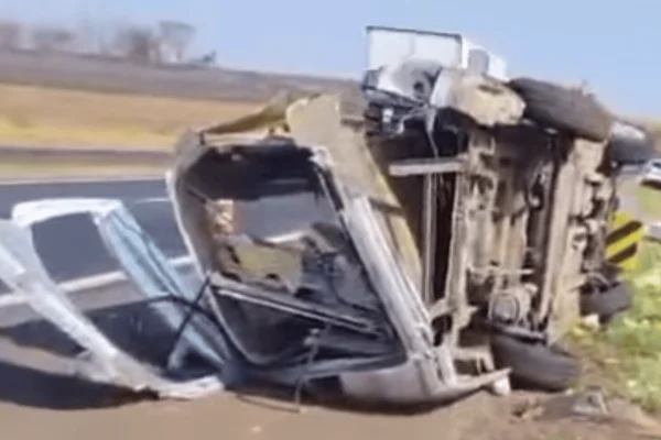 Imagem colorida de um carro capotado após a motorista bater em uma defesa metálica da rodovia - Metrópoles