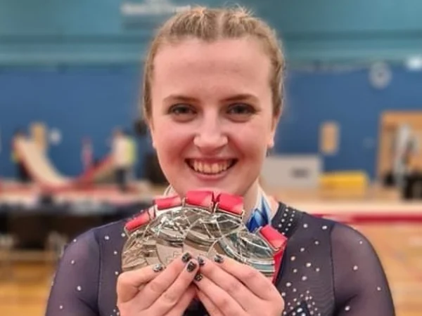 fotografia de ginasta de 27 anos segurando medalhas