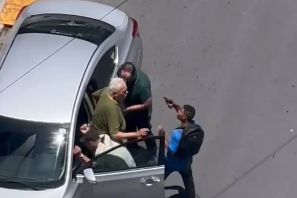 foto colorida de carro com homem idoso sendo abordado por dois homens - metrópoles