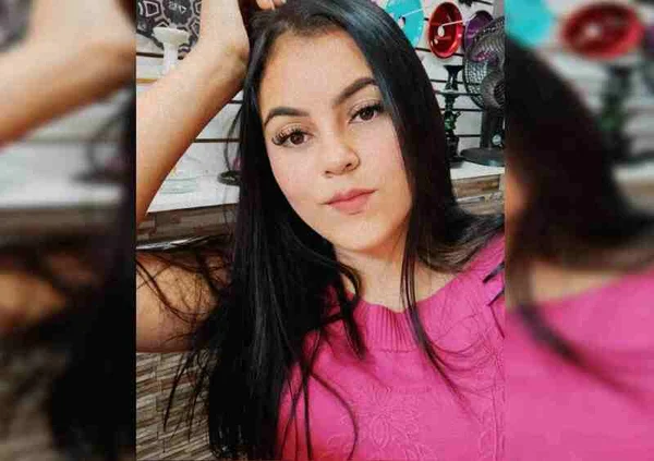 Jovem de camisa rosa segurando cabelo