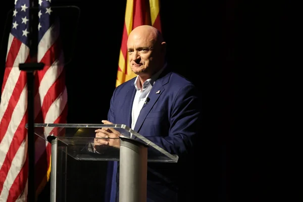 Imagem colorida com Mark Kelly, senador democrata dos EUA, veste um blazer azul. Ao fundo, a bandeira norte-americana - Metrópoles