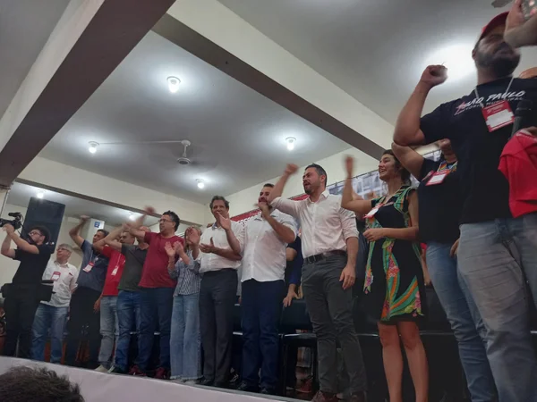 Políticos enfileirados com os braços para cima - Metrópoles