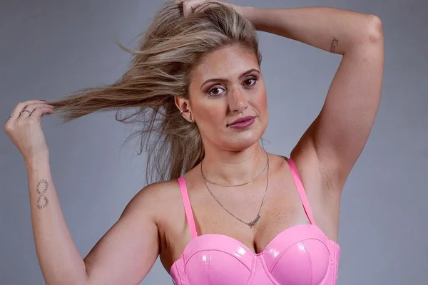 Foto colorida de Karen Bacic, do Casamento às Cegas 3. Ela é branca, loira, está usando uma blusa rosa e está com colar - Metrópoles