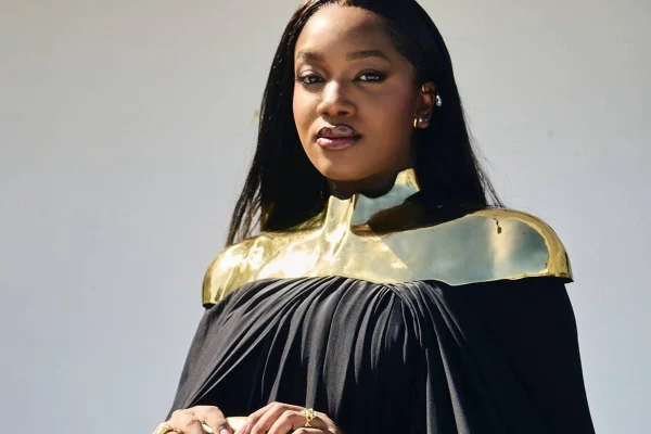 Na foto colorida, cantora IZA aparece com roupa preta e ombreira dourada, durante premiação do Grammy Latino 2024 - Metrópoles