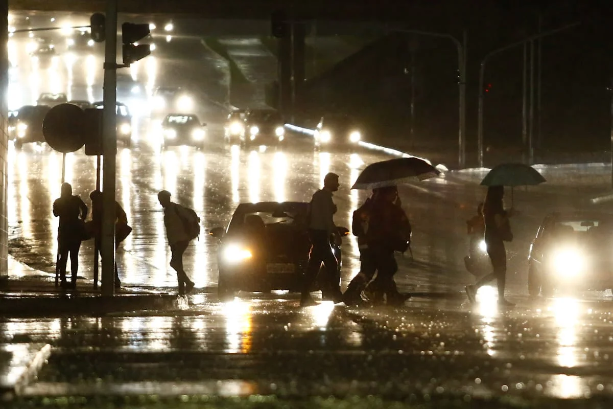 Pedestres atravessam Eixo Monumental na chuva Pedestres atravessam Eixo Monumental na chuva