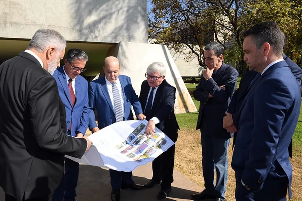 Imagem colorida de políticos e ministros com projeto de NIemeyer para reforma do STJ