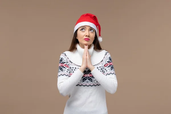 Mulher em posição de oração com gorro de Natal