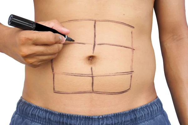 foto colorida de homem desenhando tanquinho na barriga